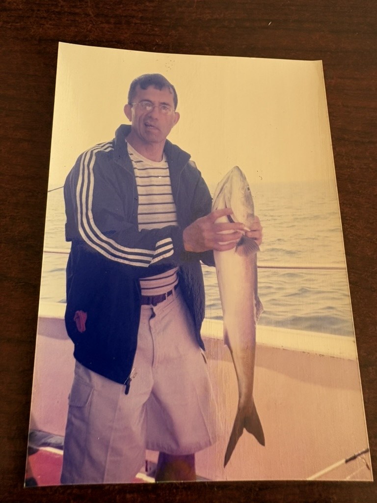 Younus Samadzada holding a large fish on a boat
