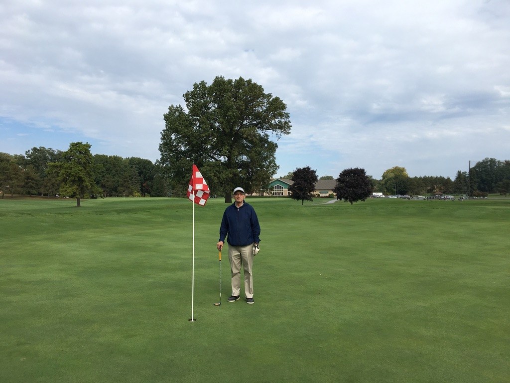 Younus Samadzada standing beside a red and white golf flag